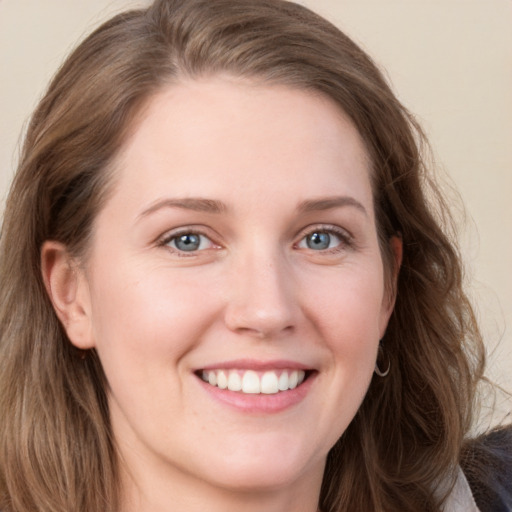 Joyful white young-adult female with long  brown hair and grey eyes