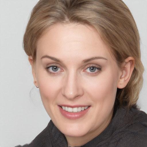 Joyful white adult female with medium  brown hair and grey eyes