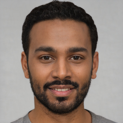 Joyful latino young-adult male with short  black hair and brown eyes