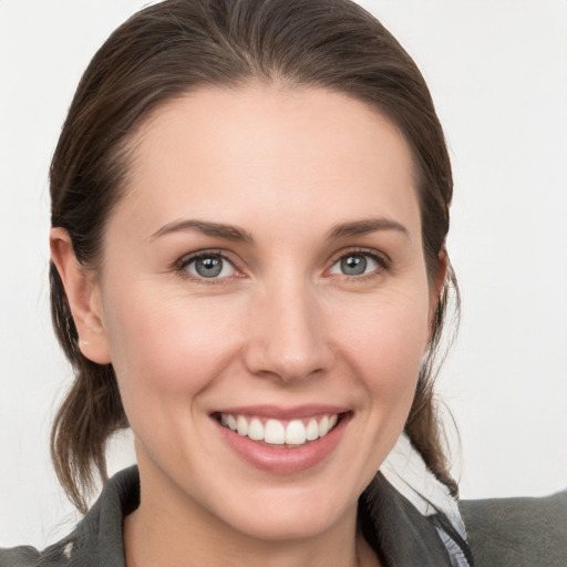 Joyful white young-adult female with medium  brown hair and grey eyes