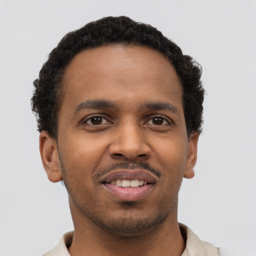 Joyful black young-adult male with short  brown hair and brown eyes