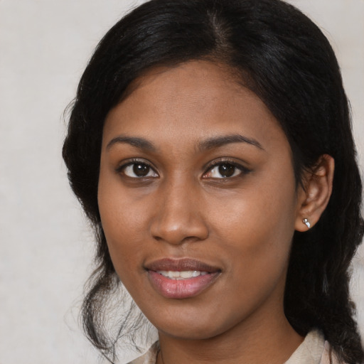 Joyful black young-adult female with medium  brown hair and brown eyes