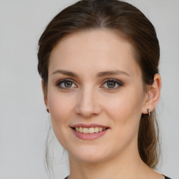 Joyful white young-adult female with medium  brown hair and green eyes