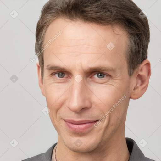 Joyful white adult male with short  brown hair and grey eyes