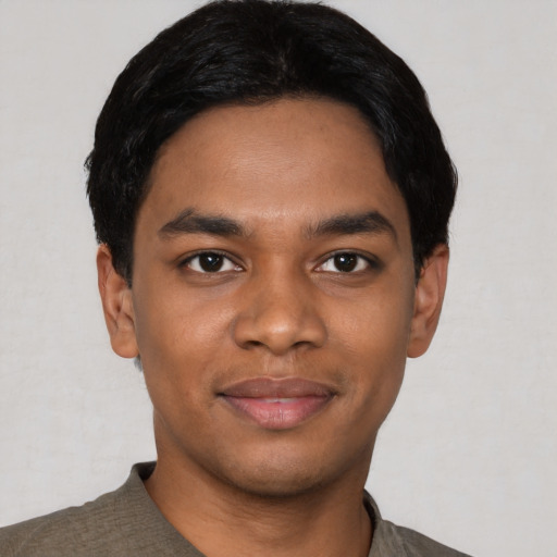 Joyful black young-adult male with short  black hair and brown eyes