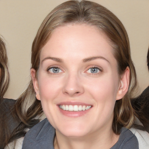 Joyful white adult female with medium  brown hair and blue eyes