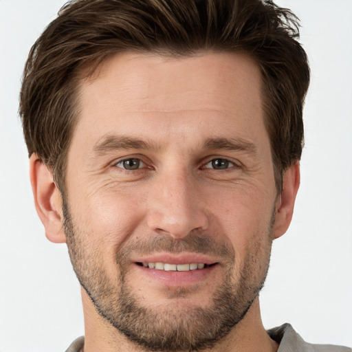 Joyful white adult male with short  brown hair and grey eyes