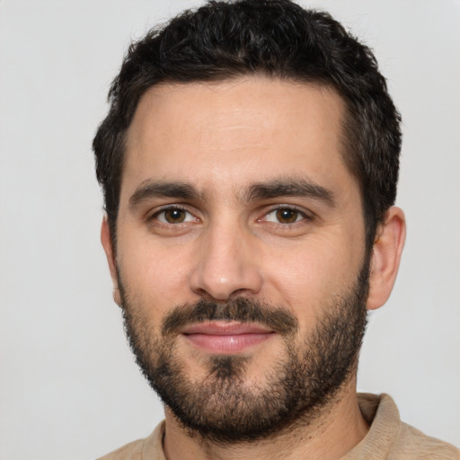 Joyful white young-adult male with short  black hair and brown eyes
