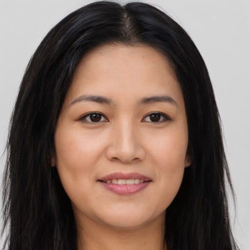 Joyful asian young-adult female with long  brown hair and brown eyes
