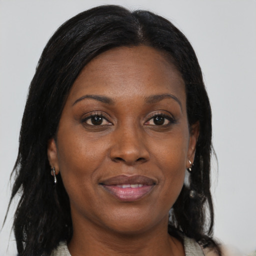 Joyful black adult female with long  brown hair and brown eyes