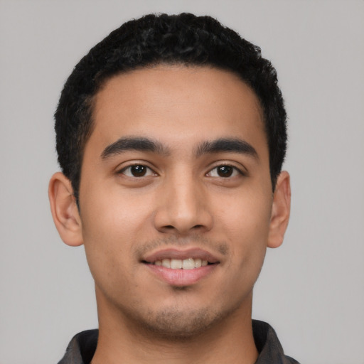 Joyful latino young-adult male with short  black hair and brown eyes
