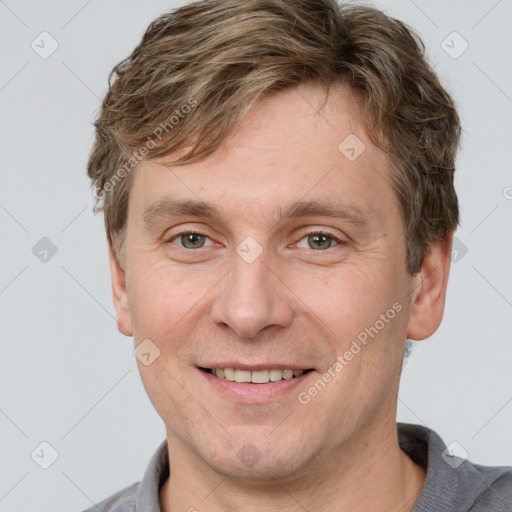 Joyful white adult male with short  brown hair and grey eyes