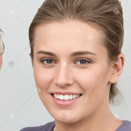 Joyful white young-adult female with medium  brown hair and grey eyes