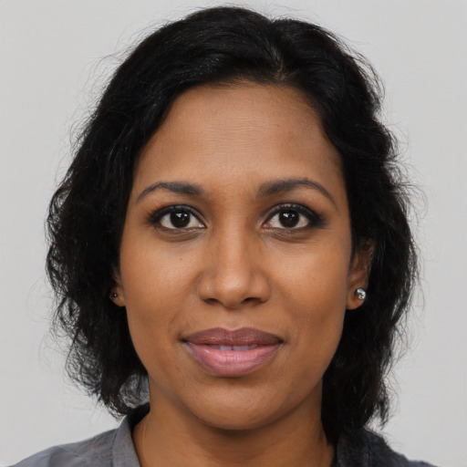 Joyful black young-adult female with medium  brown hair and brown eyes