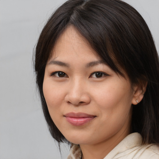 Joyful asian young-adult female with medium  brown hair and brown eyes
