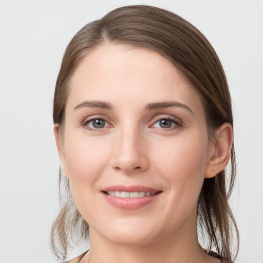 Joyful white young-adult female with medium  brown hair and grey eyes