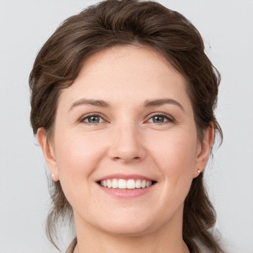 Joyful white young-adult female with medium  brown hair and grey eyes