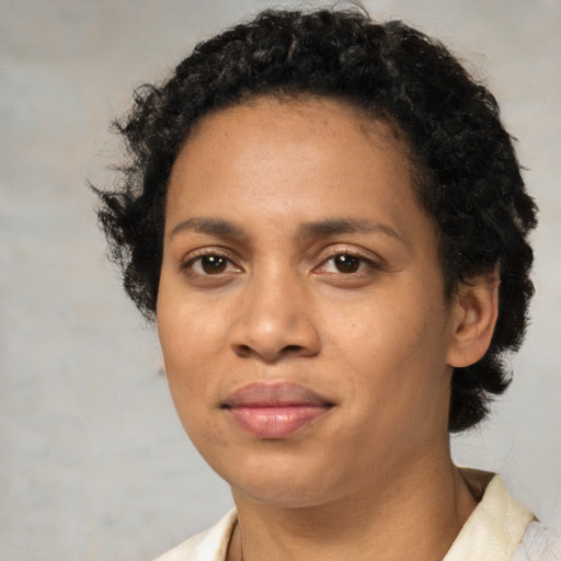 Joyful black adult female with short  black hair and brown eyes