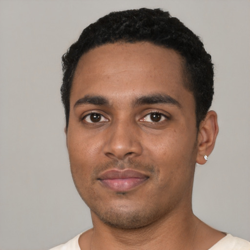 Joyful black young-adult male with short  black hair and brown eyes