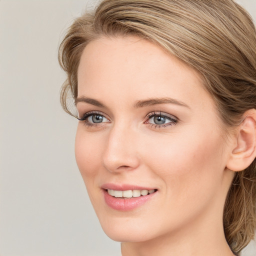 Joyful white young-adult female with long  brown hair and blue eyes