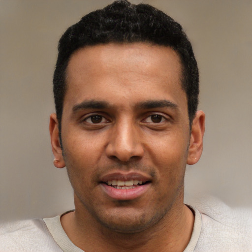 Joyful black young-adult male with short  black hair and brown eyes
