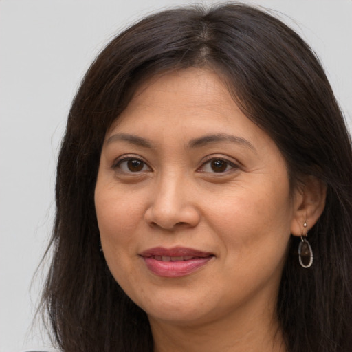 Joyful latino adult female with long  brown hair and brown eyes