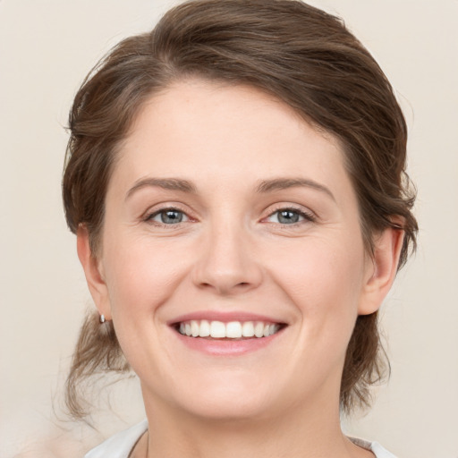 Joyful white young-adult female with medium  brown hair and green eyes