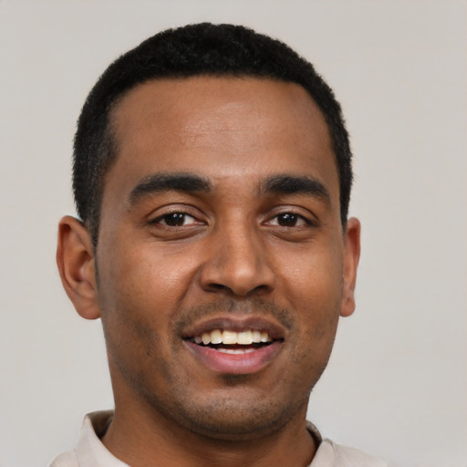Joyful black young-adult male with short  black hair and brown eyes