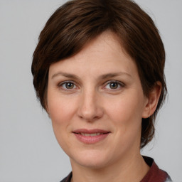 Joyful white young-adult female with medium  brown hair and grey eyes