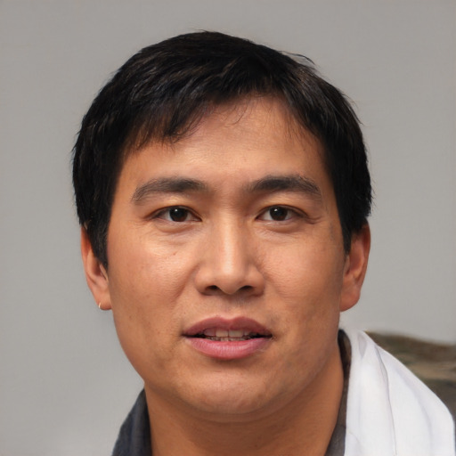 Joyful asian adult male with short  black hair and brown eyes