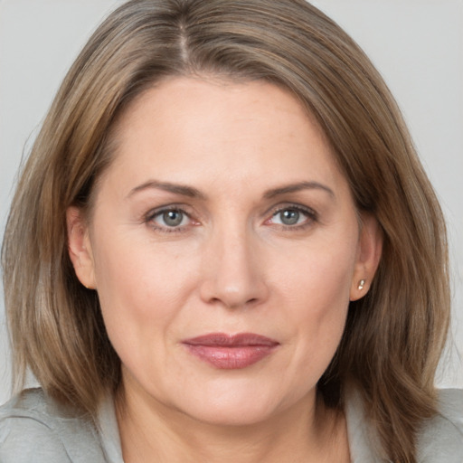 Joyful white adult female with medium  brown hair and grey eyes