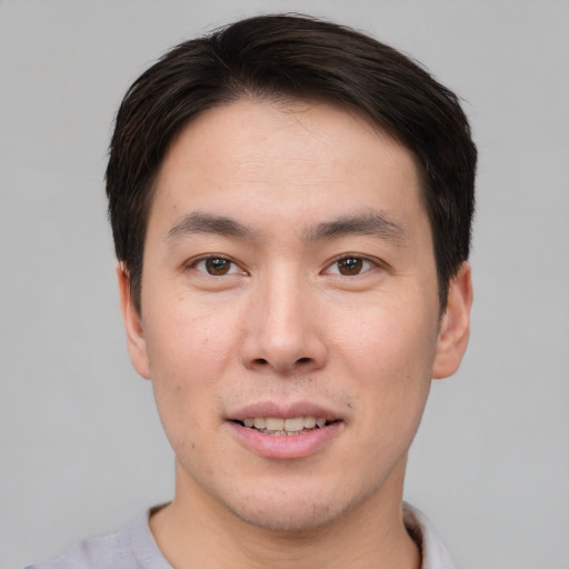 Joyful asian young-adult male with short  brown hair and brown eyes