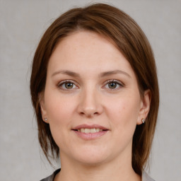 Joyful white young-adult female with medium  brown hair and grey eyes