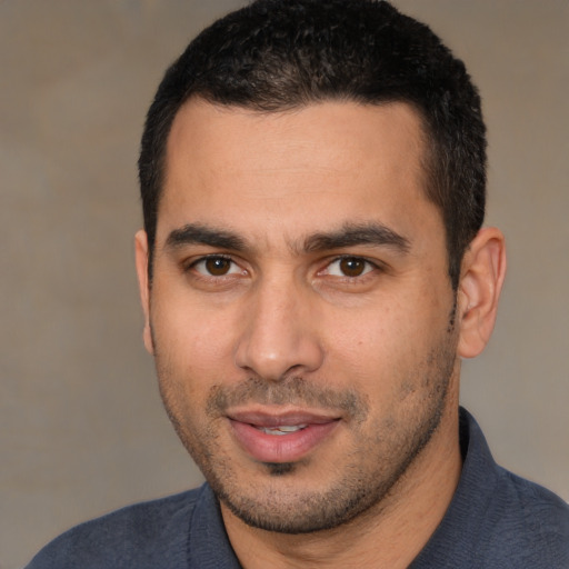 Joyful white young-adult male with short  black hair and brown eyes