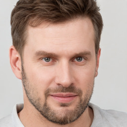 Joyful white young-adult male with short  brown hair and grey eyes