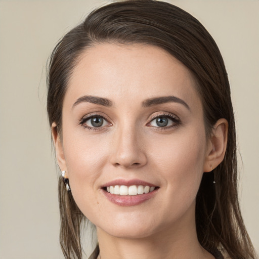 Joyful white young-adult female with long  brown hair and grey eyes