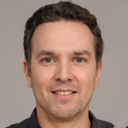 Joyful white adult male with short  brown hair and grey eyes