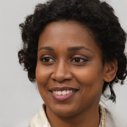 Joyful black young-adult female with long  brown hair and brown eyes