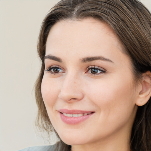 Joyful white young-adult female with long  brown hair and brown eyes