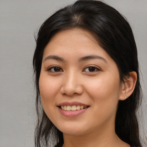 Joyful asian young-adult female with long  brown hair and brown eyes