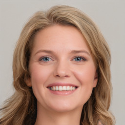 Joyful white young-adult female with long  brown hair and blue eyes