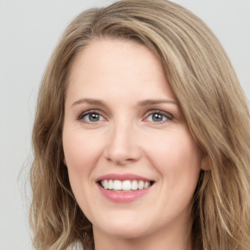 Joyful white young-adult female with long  brown hair and green eyes