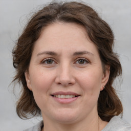 Joyful white adult female with medium  brown hair and grey eyes