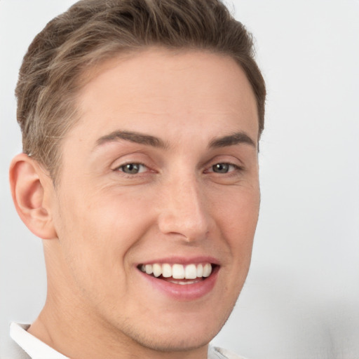 Joyful white young-adult male with short  brown hair and grey eyes