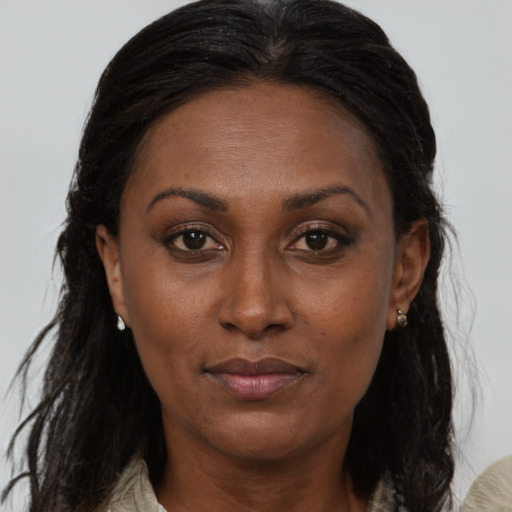 Joyful black adult female with long  brown hair and brown eyes