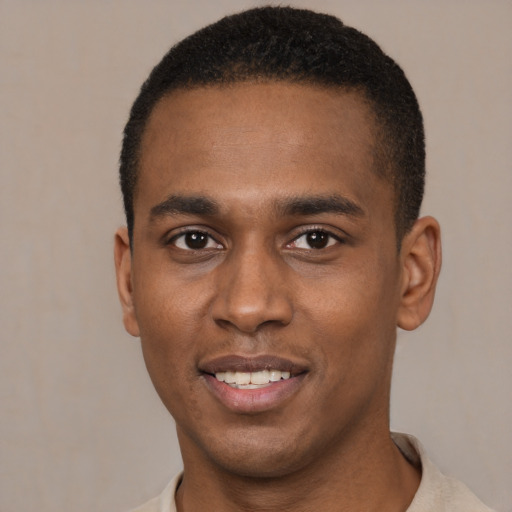 Joyful black young-adult male with short  black hair and brown eyes
