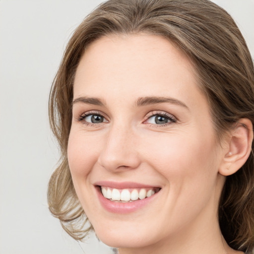 Joyful white young-adult female with long  brown hair and blue eyes