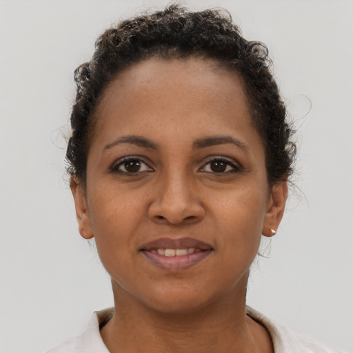 Joyful black young-adult female with short  brown hair and brown eyes