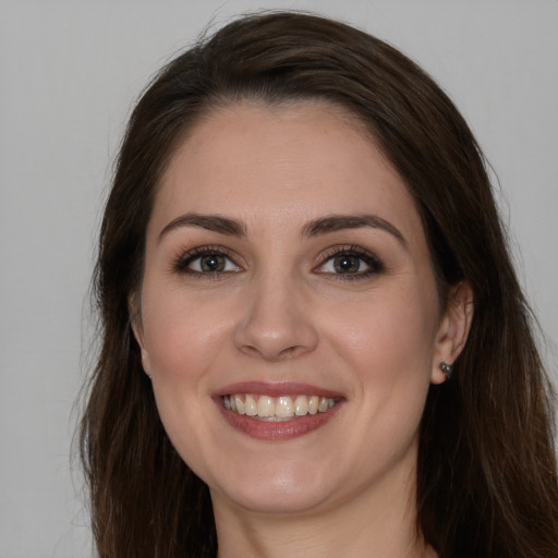 Joyful white young-adult female with long  brown hair and brown eyes