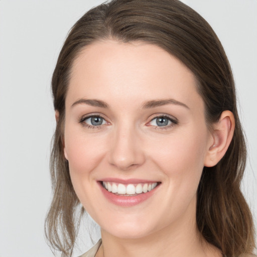 Joyful white young-adult female with medium  brown hair and grey eyes